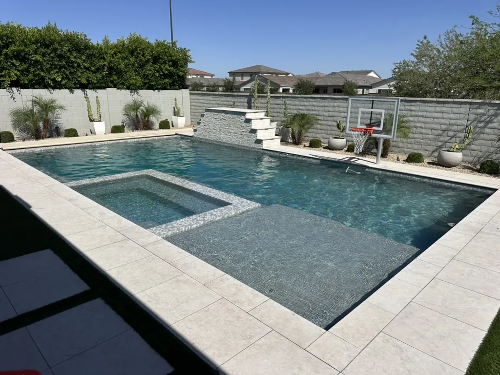 Geometric pool with attached spa and basketball hoop in Gilbert, AZ