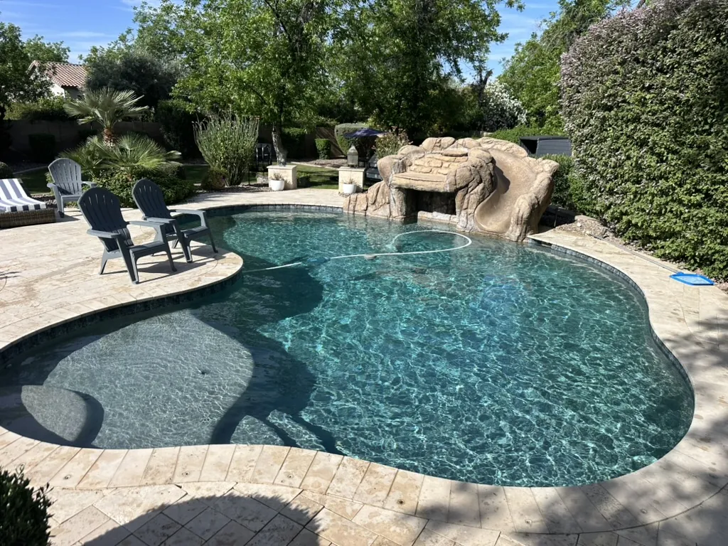 Freeform pool with rock slide and tanning shelf